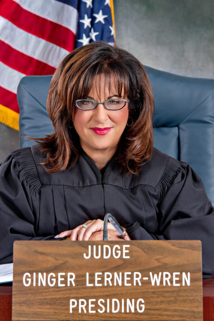 Judge Wren sat in her robes in front of the US Flag